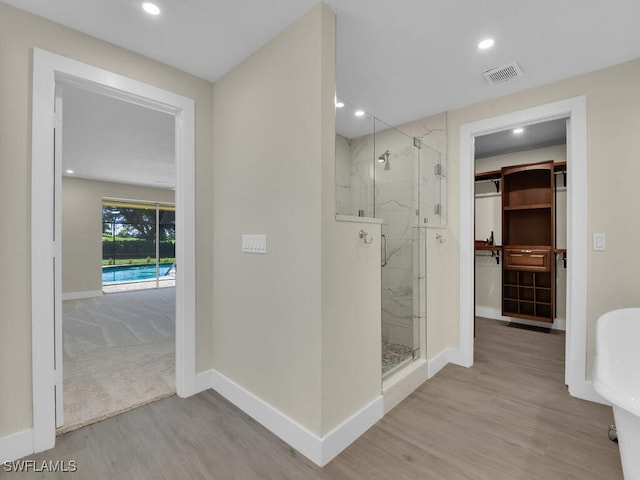 bathroom with wood-type flooring and a shower with door