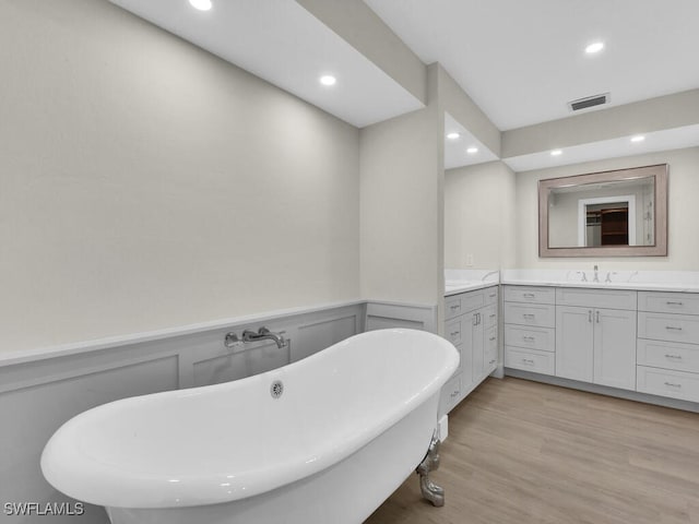 bathroom with vanity, hardwood / wood-style floors, and a washtub