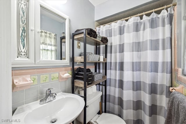 bathroom featuring a shower with shower curtain, sink, tasteful backsplash, and toilet