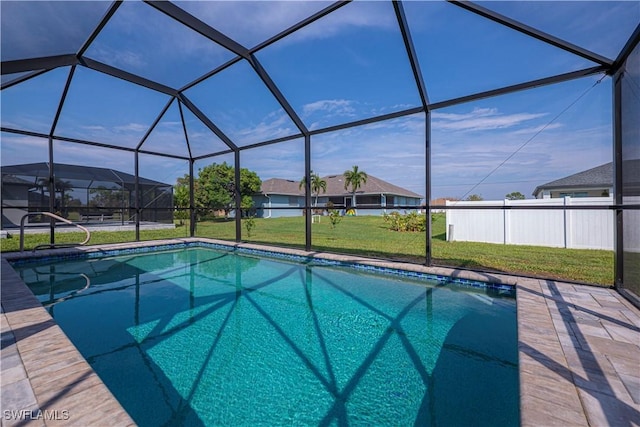 view of swimming pool with glass enclosure, a patio area, and a lawn