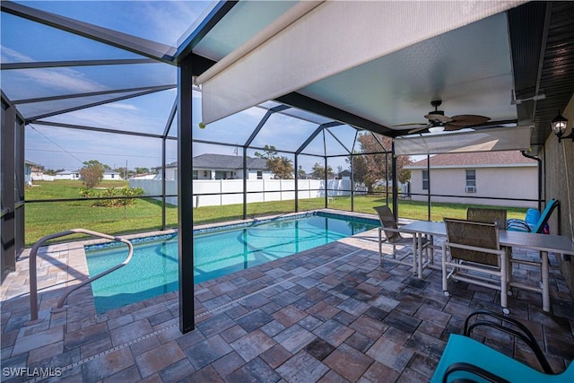 view of pool featuring a lawn, a patio area, and glass enclosure