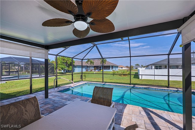 view of pool with glass enclosure, a yard, and a patio