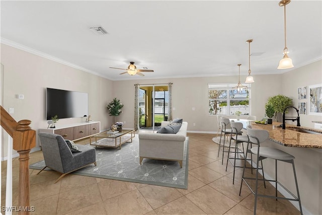 living room featuring crown molding, ceiling fan with notable chandelier, sink, and light tile patterned floors