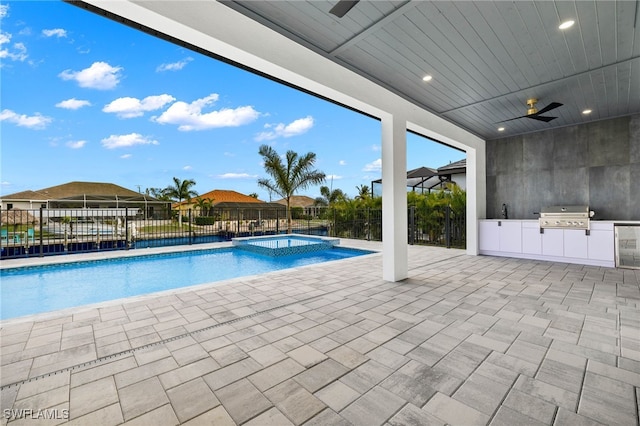 view of swimming pool featuring exterior kitchen, a grill, a patio area, and ceiling fan