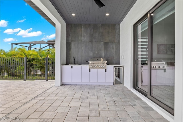 view of patio / terrace with wine cooler, area for grilling, and sink