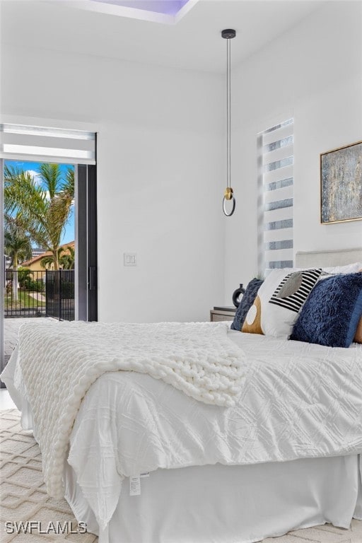 bedroom with access to exterior, multiple windows, and carpet