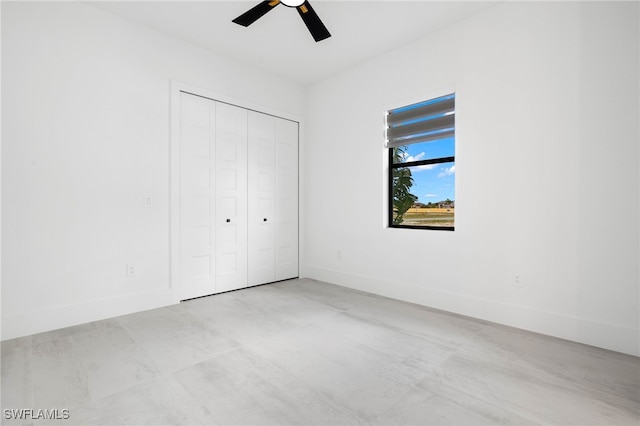 unfurnished bedroom featuring ceiling fan and a closet