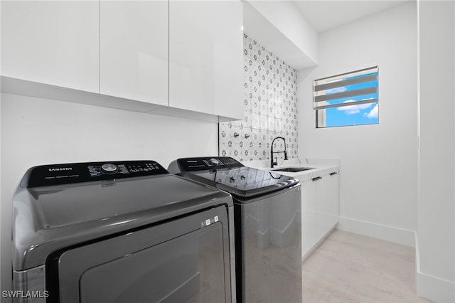 laundry room featuring cabinets, sink, and washer and dryer