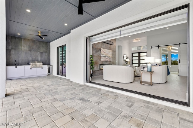 view of patio with an outdoor kitchen, area for grilling, wine cooler, and ceiling fan