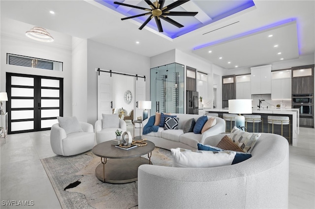 living room featuring ceiling fan, french doors, a barn door, and a wealth of natural light