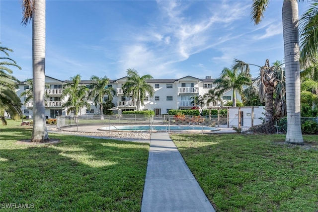 view of property's community featuring a pool and a yard