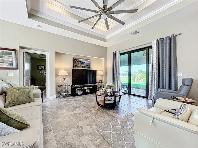 living room with a tray ceiling, ceiling fan, and ornamental molding