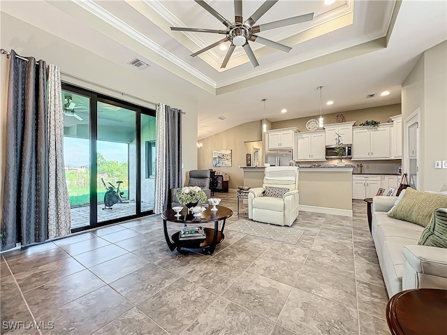 living room featuring ceiling fan, a raised ceiling, and crown molding