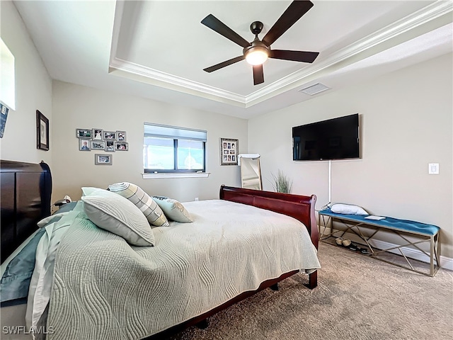 carpeted bedroom featuring a tray ceiling, ceiling fan, and crown molding