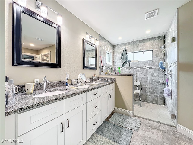 bathroom featuring tiled shower and vanity