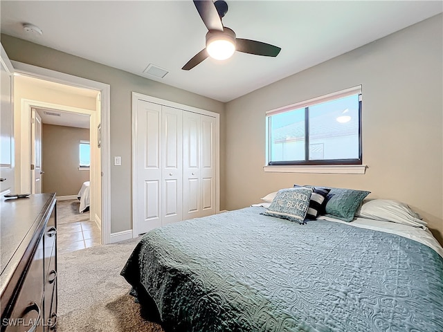 tiled bedroom featuring ceiling fan and a closet