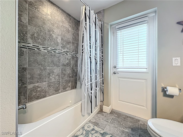 bathroom with toilet and shower / bath combo with shower curtain