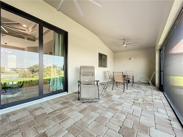 unfurnished sunroom featuring ceiling fan with notable chandelier, a healthy amount of sunlight, and lofted ceiling