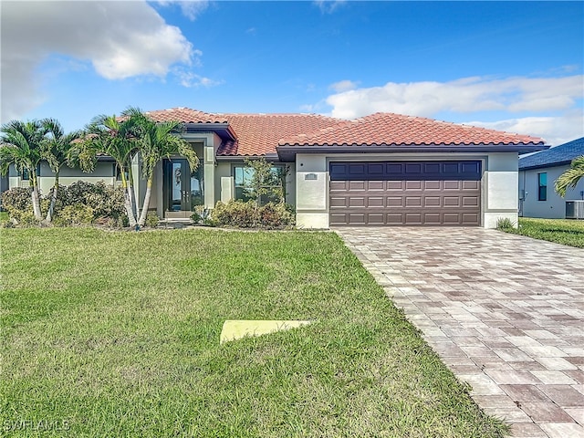 mediterranean / spanish home with a front yard, a garage, and central air condition unit