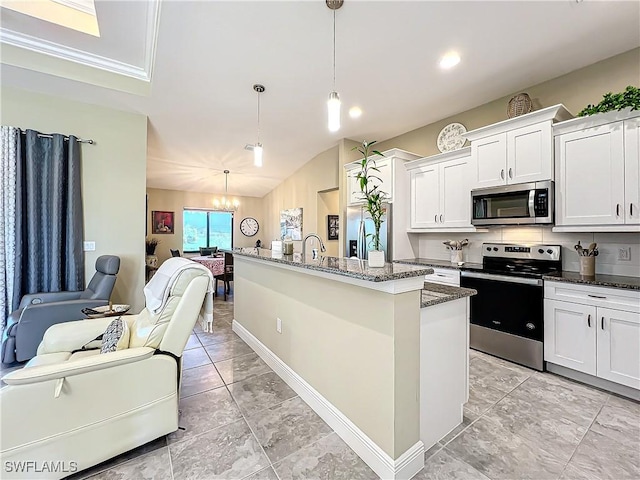 646 NE 5th Place, Cape Coral, FL 33909 - kitchen with stainless steel appliances, open floor plan, a chandelier, dark stone counters, and a center island with sink