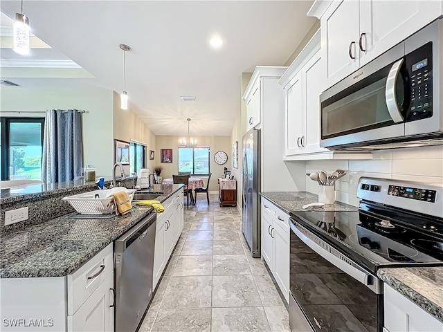 kitchen featuring white cabinets, pendant lighting, stainless steel appliances, and sink