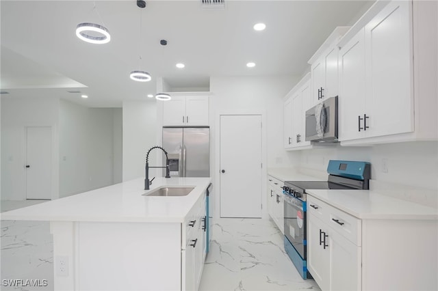 kitchen featuring stainless steel appliances, white cabinetry, marble finish floor, light countertops, and a center island with sink