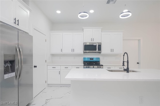 kitchen with white cabinets, a center island with sink, sink, and appliances with stainless steel finishes