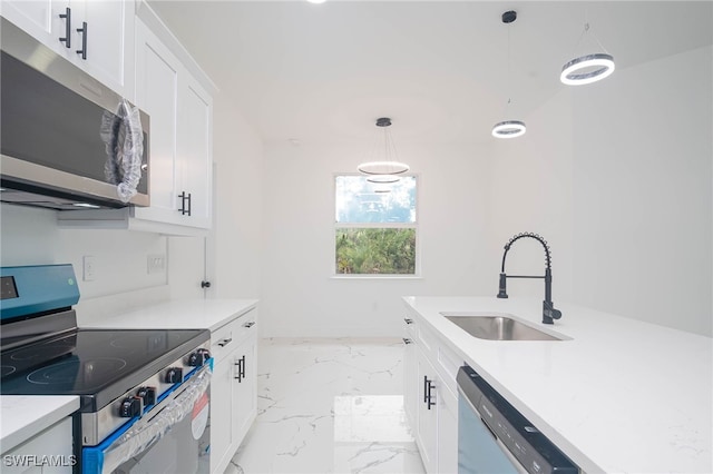 kitchen featuring white cabinetry, sink, decorative light fixtures, and appliances with stainless steel finishes