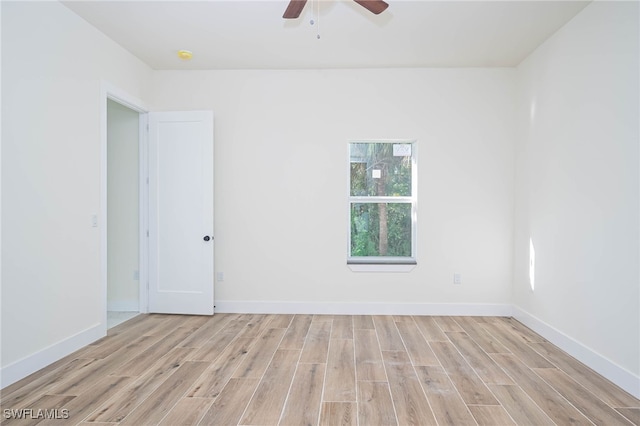 unfurnished room featuring a ceiling fan, light wood-type flooring, and baseboards