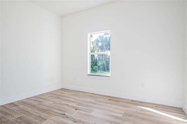 spare room with light wood-type flooring and baseboards