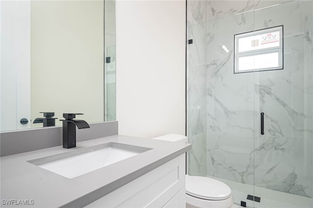 bathroom featuring vanity, a marble finish shower, and toilet