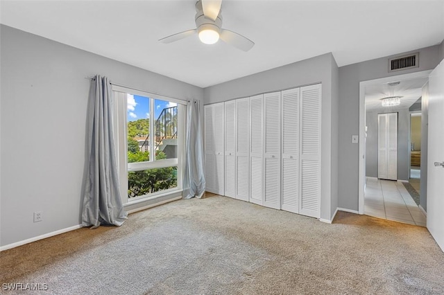 unfurnished bedroom featuring ceiling fan, a closet, and carpet