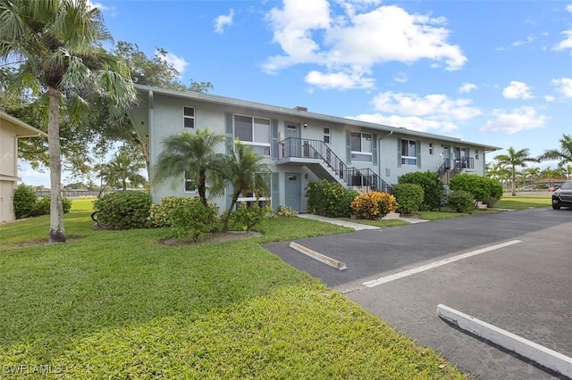 197 Harrison Rd Unit 7-3, Naples, FL 34112 - view of building exterior featuring stairway and uncovered parking
