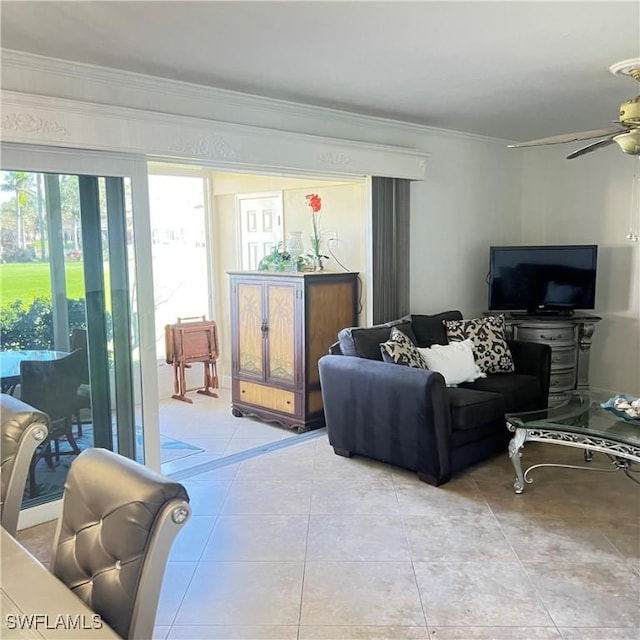 tiled living room with ceiling fan and ornamental molding