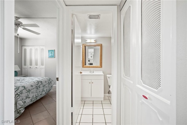 interior space with vanity, tile patterned floors, and ceiling fan