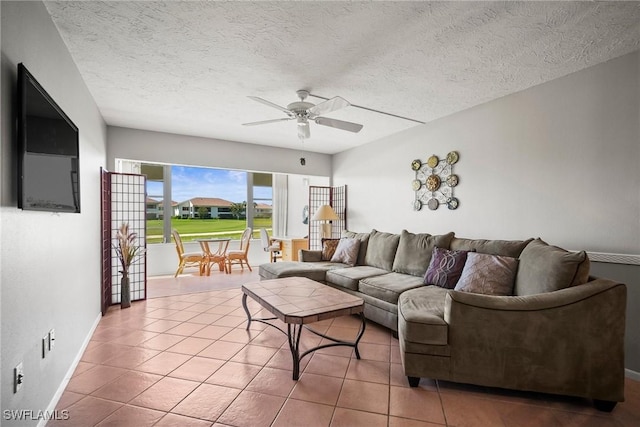 living room featuring light tile patterned flooring, ceiling fan, and a textured ceiling