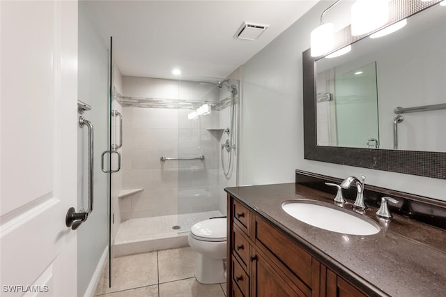 bathroom with vanity, toilet, tile patterned floors, and walk in shower