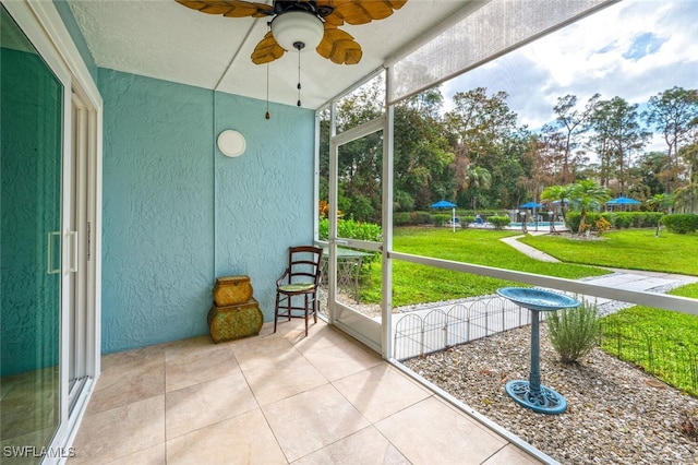 unfurnished sunroom with ceiling fan