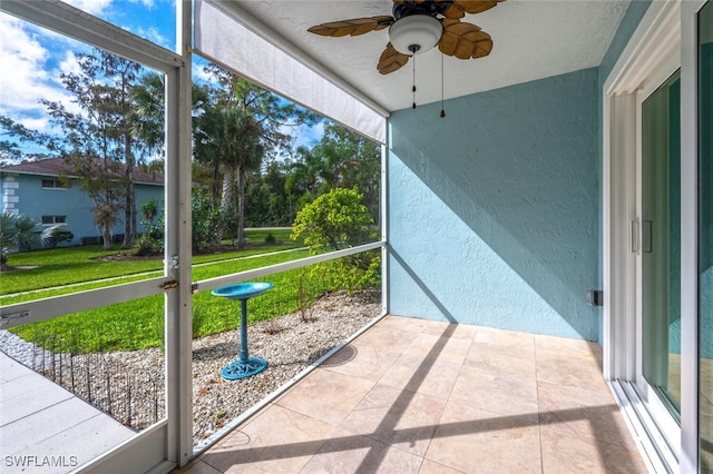 unfurnished sunroom with ceiling fan