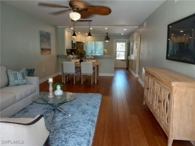 living room with dark wood-type flooring, recessed lighting, baseboards, and a ceiling fan