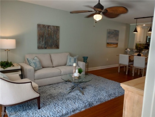 living room with ceiling fan, wood finished floors, and baseboards