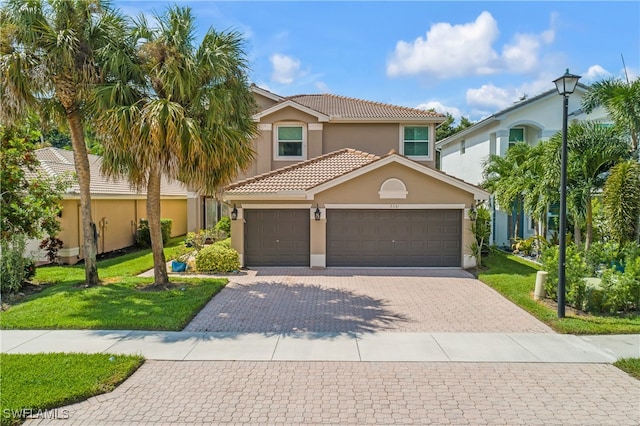 mediterranean / spanish home with a garage and a front lawn