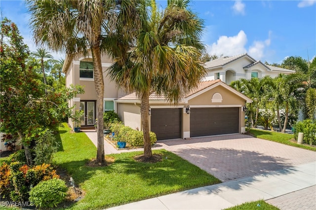 mediterranean / spanish-style home with a front yard and a garage