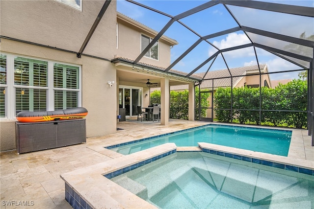 view of swimming pool with an in ground hot tub, ceiling fan, a patio area, and a lanai