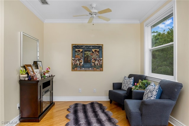 sitting room featuring ornamental molding, ceiling fan, and wood-type flooring