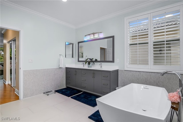 bathroom with wood-type flooring, a bathtub, crown molding, and vanity