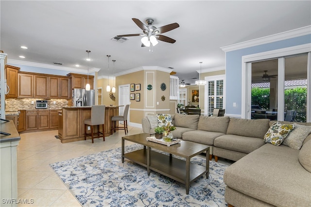 living room with light tile patterned flooring, crown molding, and ceiling fan