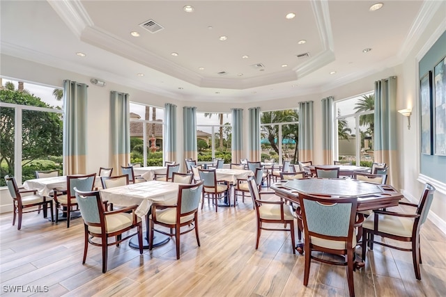 dining area with crown molding and light hardwood / wood-style flooring