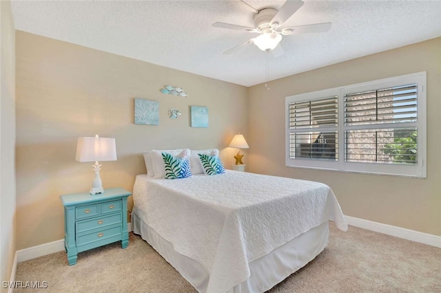 bedroom with ceiling fan, a textured ceiling, and light carpet