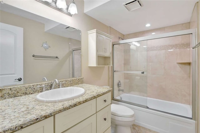 full bathroom featuring shower / bath combination with glass door, toilet, and vanity